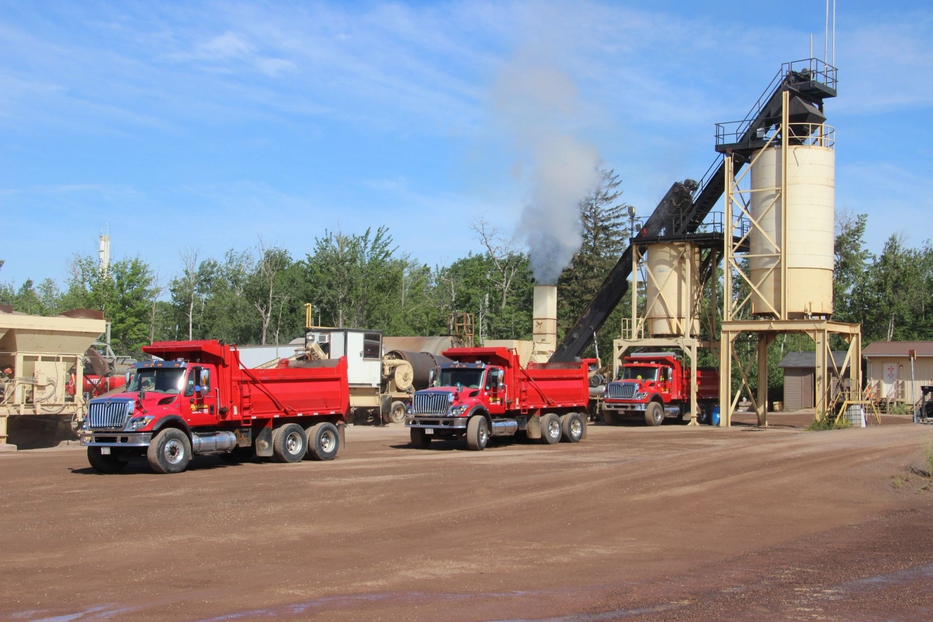 MacArthur's drum-mix asphalt plant on Galloway Street with red dump trucks loading hot mix