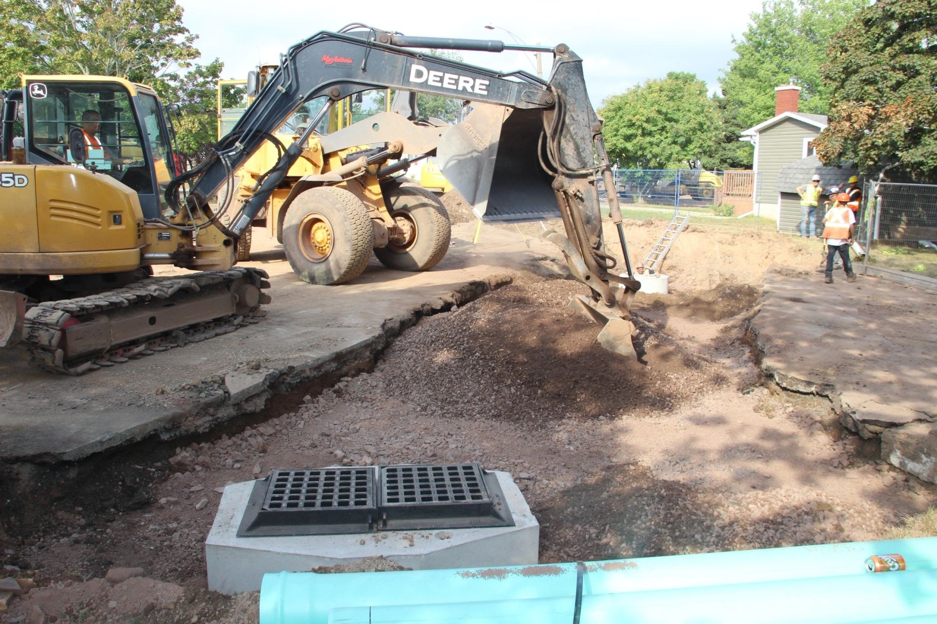 MacArthur's excavator setting a catch basin and water main on a municipal street job