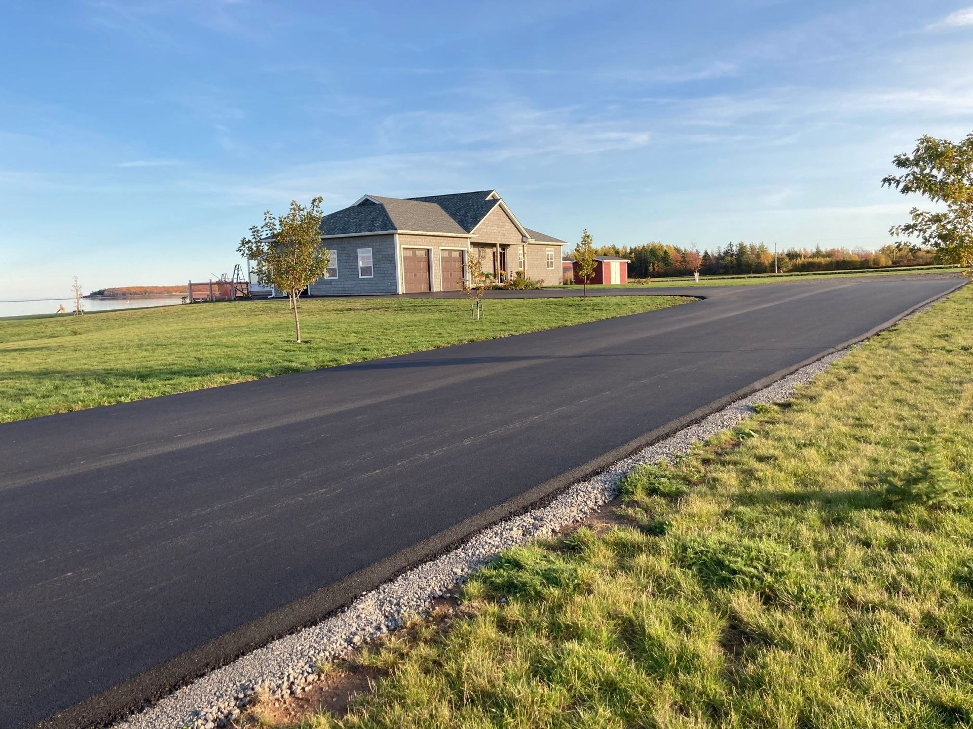 Freshly paved residential driveway curving to a home in South Eastern New Brunswick